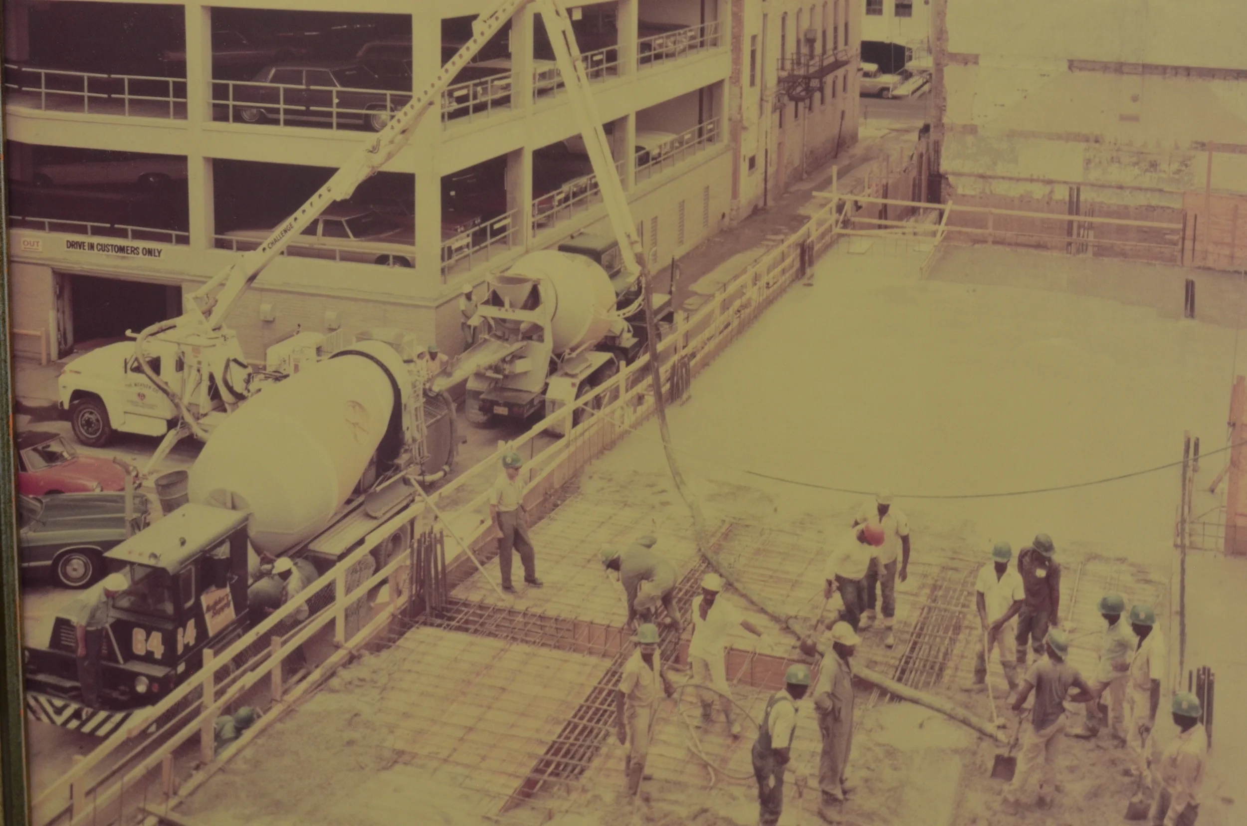 This picture shows the construction of the Commercial National Bank parking garage job in 1976. Notice the Crane Carrier concrete truck with the half cab.